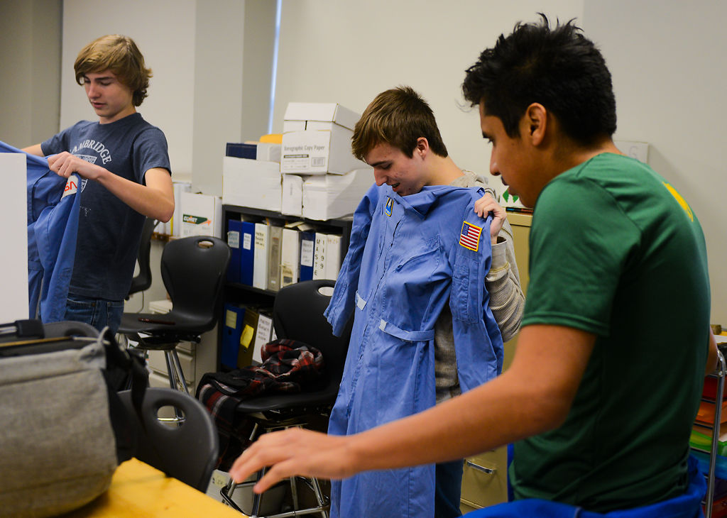 Alec Hume, Freddie Boland, and Allen Whitaker fold up their space suits